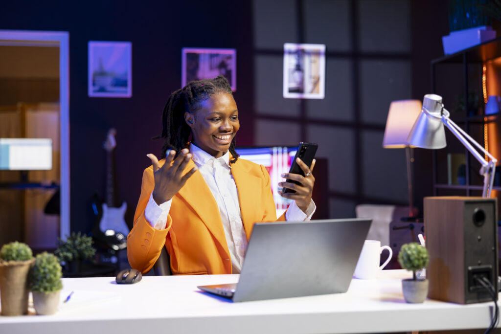 happy woman relaxing in apartment, texting friends on cellphone